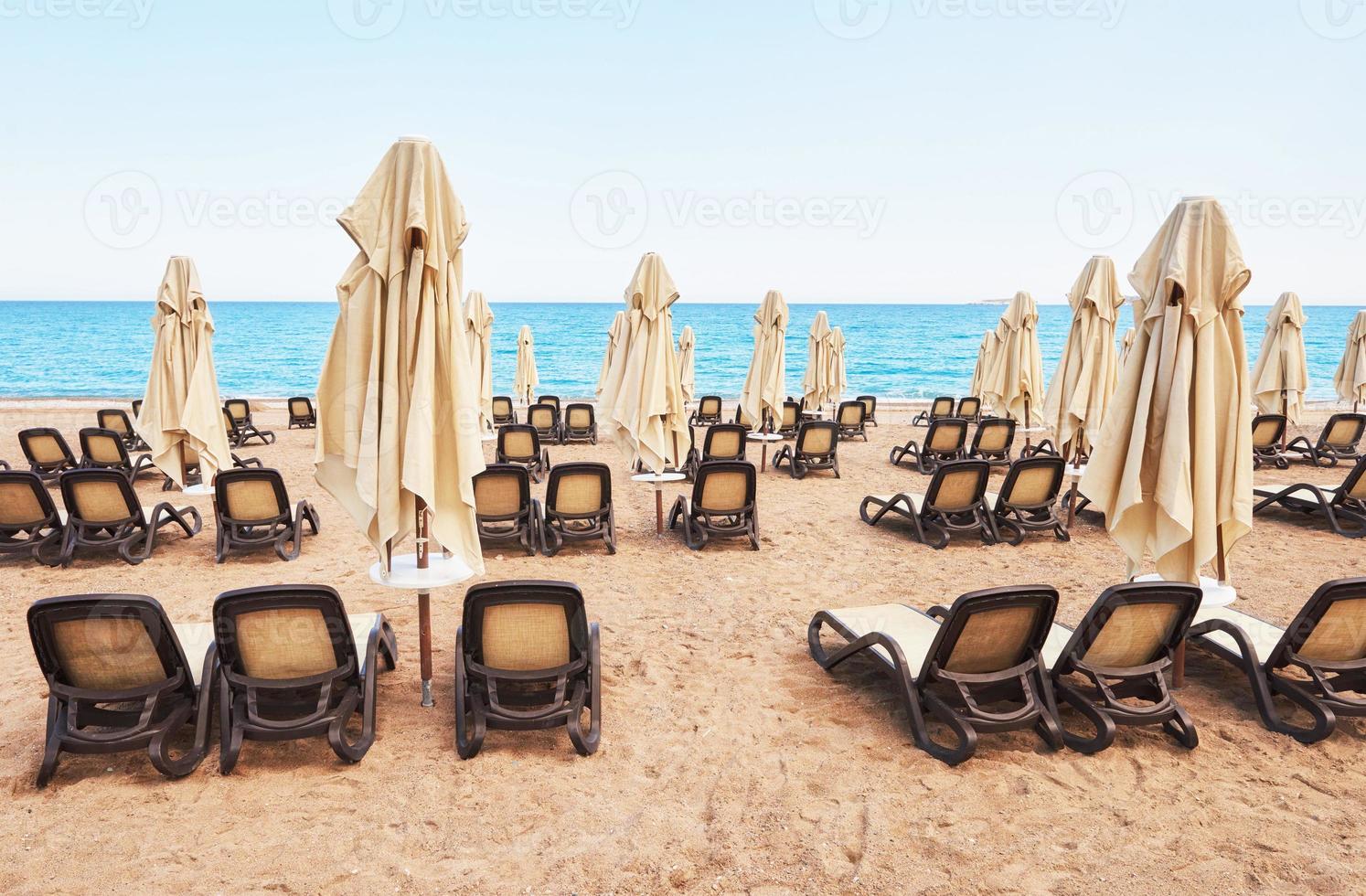 Scenic view of private sandy beach with sun beds from the sea and the mountains. Amara Dols Vita Luxury Hotel. Resort. Tekirova Kemer. Turkey. photo