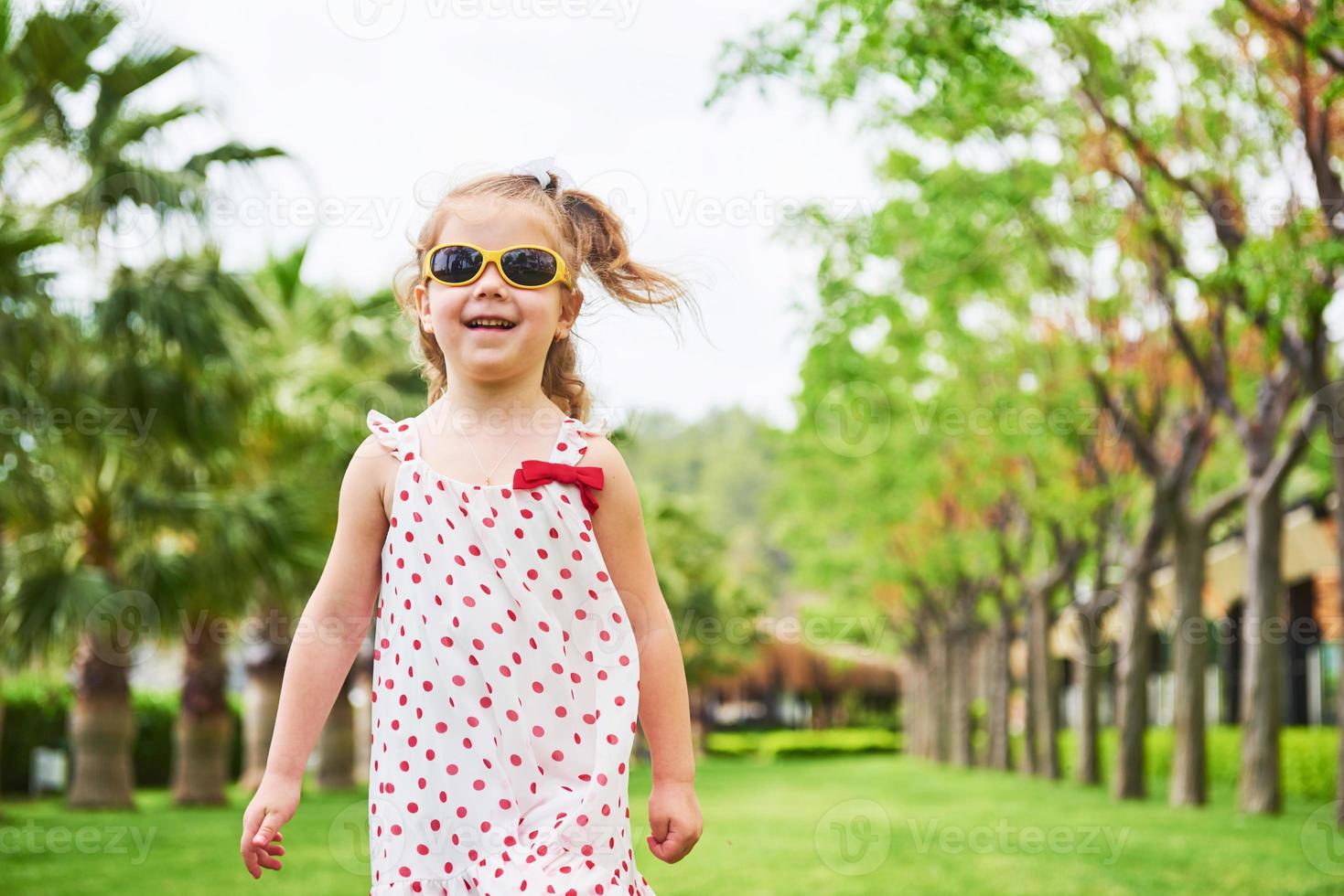 baby girl in a park near trees. photo