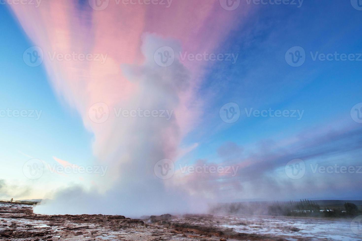 Strokkur geyser eruption in Iceland. Fantastic colors shine through the steam. photo