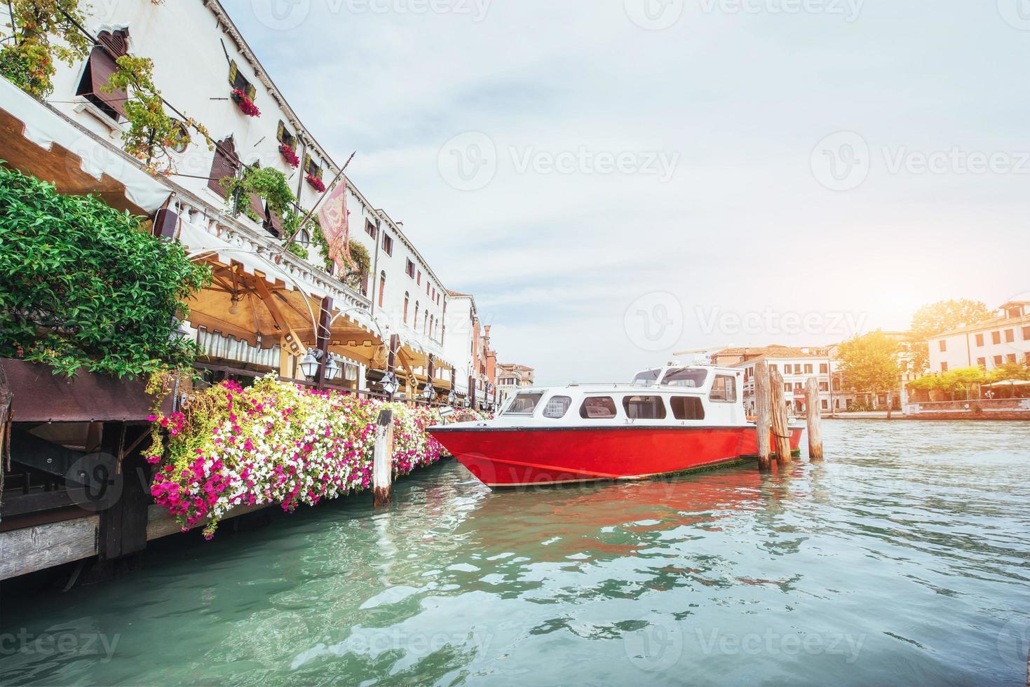 canal de agua verde con góndolas y coloridas fachadas de antiguos edificios medievales al sol en venecia, italia. foto