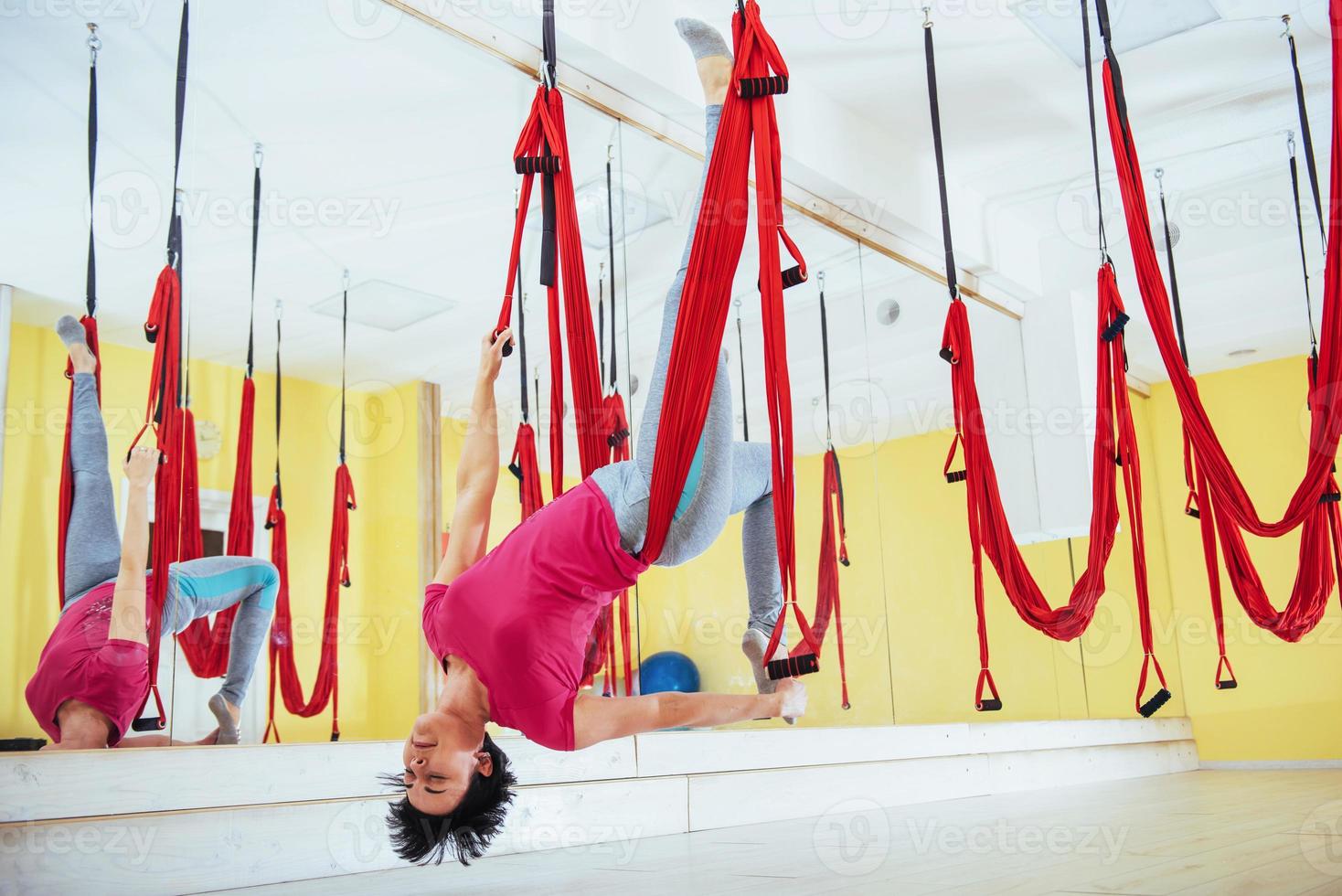 young woman making antigravity yoga exercises photo