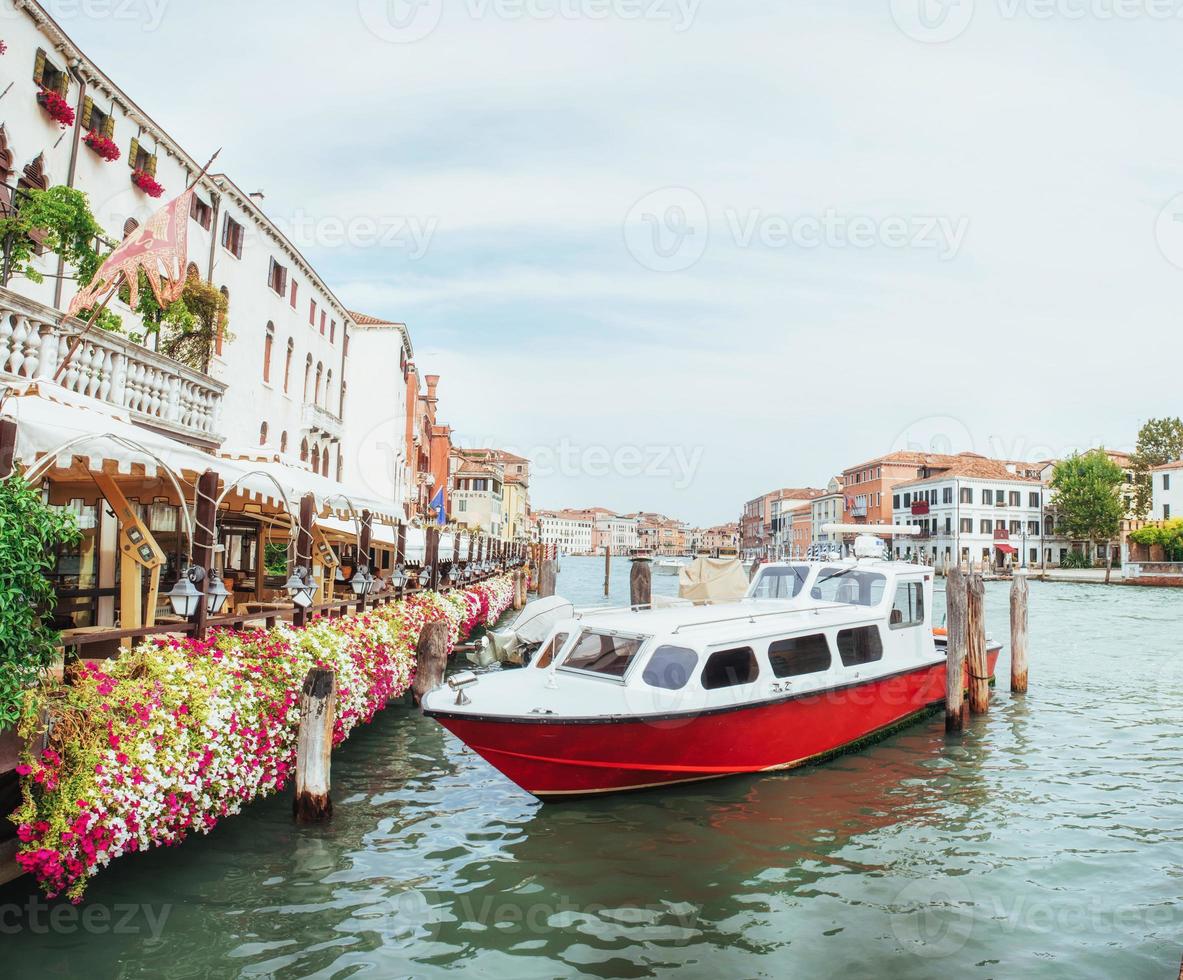 canal de agua verde con góndolas y coloridas fachadas de antiguos edificios medievales al sol en venecia foto