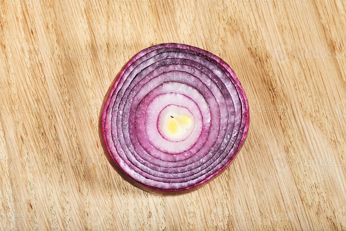 Half red onion on a wooden background photo