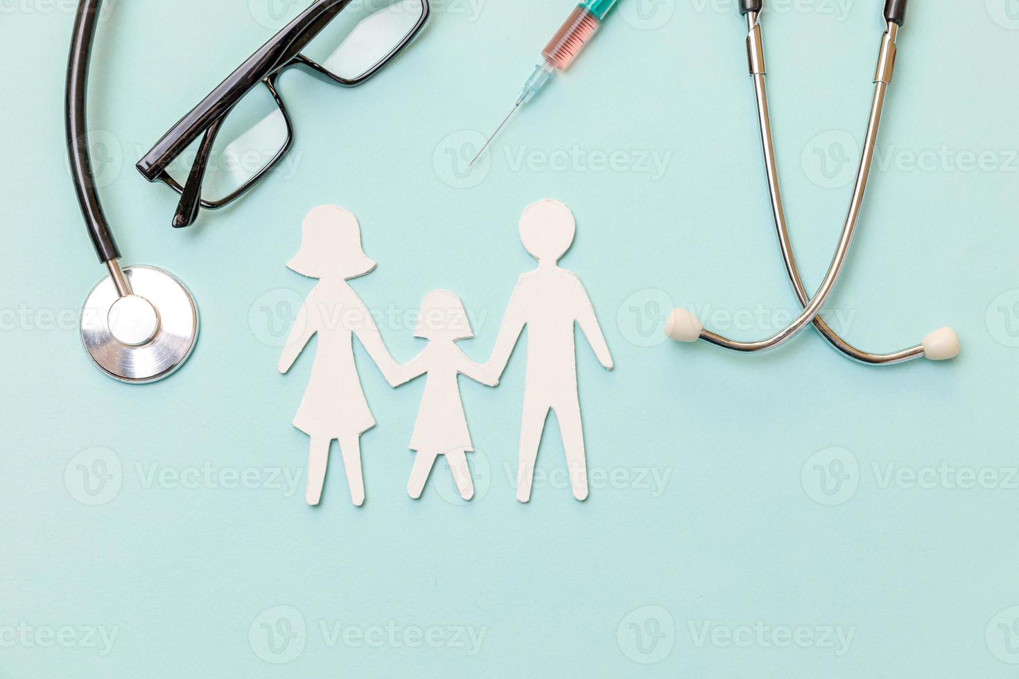 Family health care therapy medical concept. Family cutout symbol model stethoscope glasses syringe on blue background. Health check up life insurance concept. Clinic hospital for parents child banner. photo