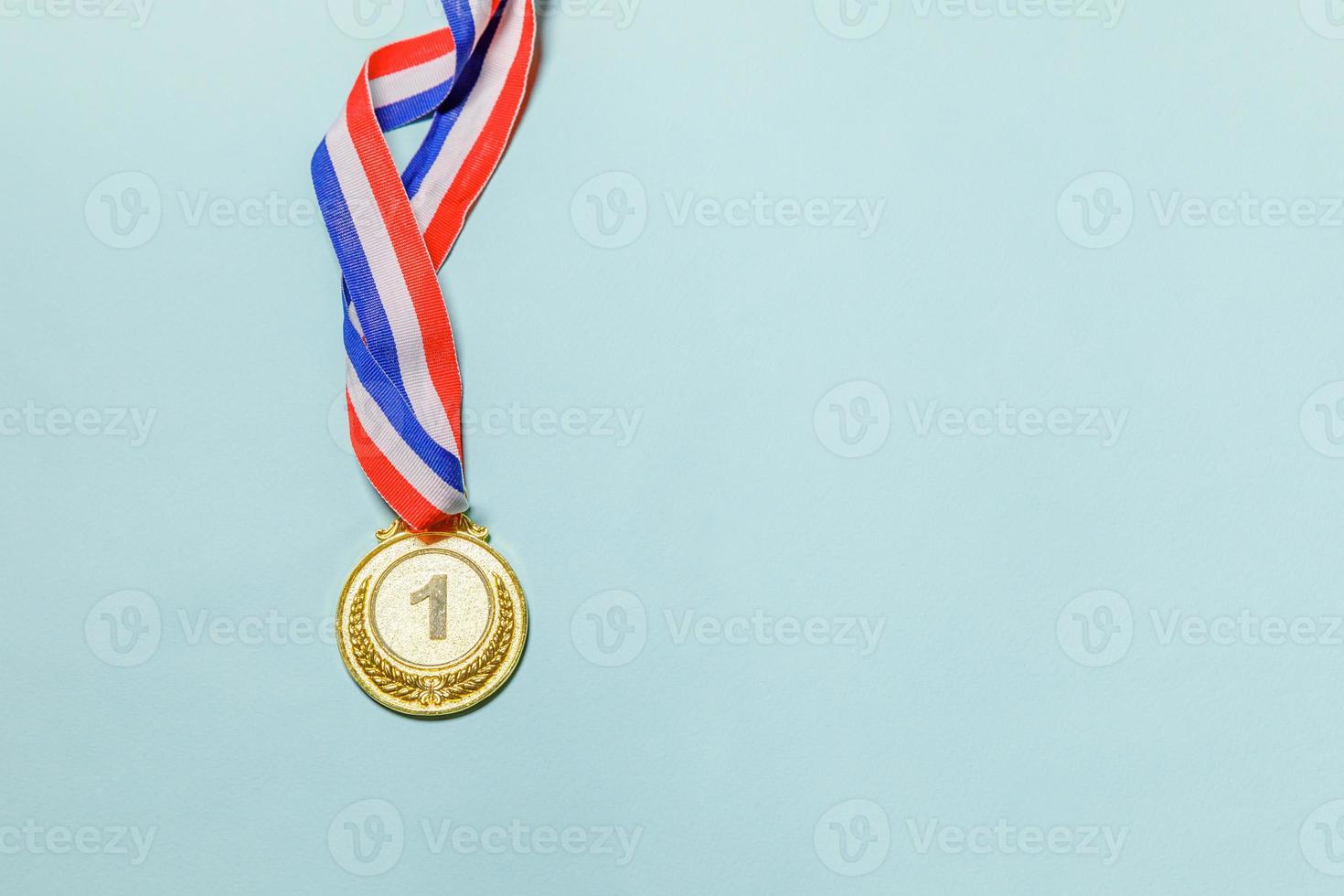 Simply flat lay design winner or champion gold trophy medal isolated on blue colorful background. Victory first place of competition. Winning or success concept. Top view copy space. photo