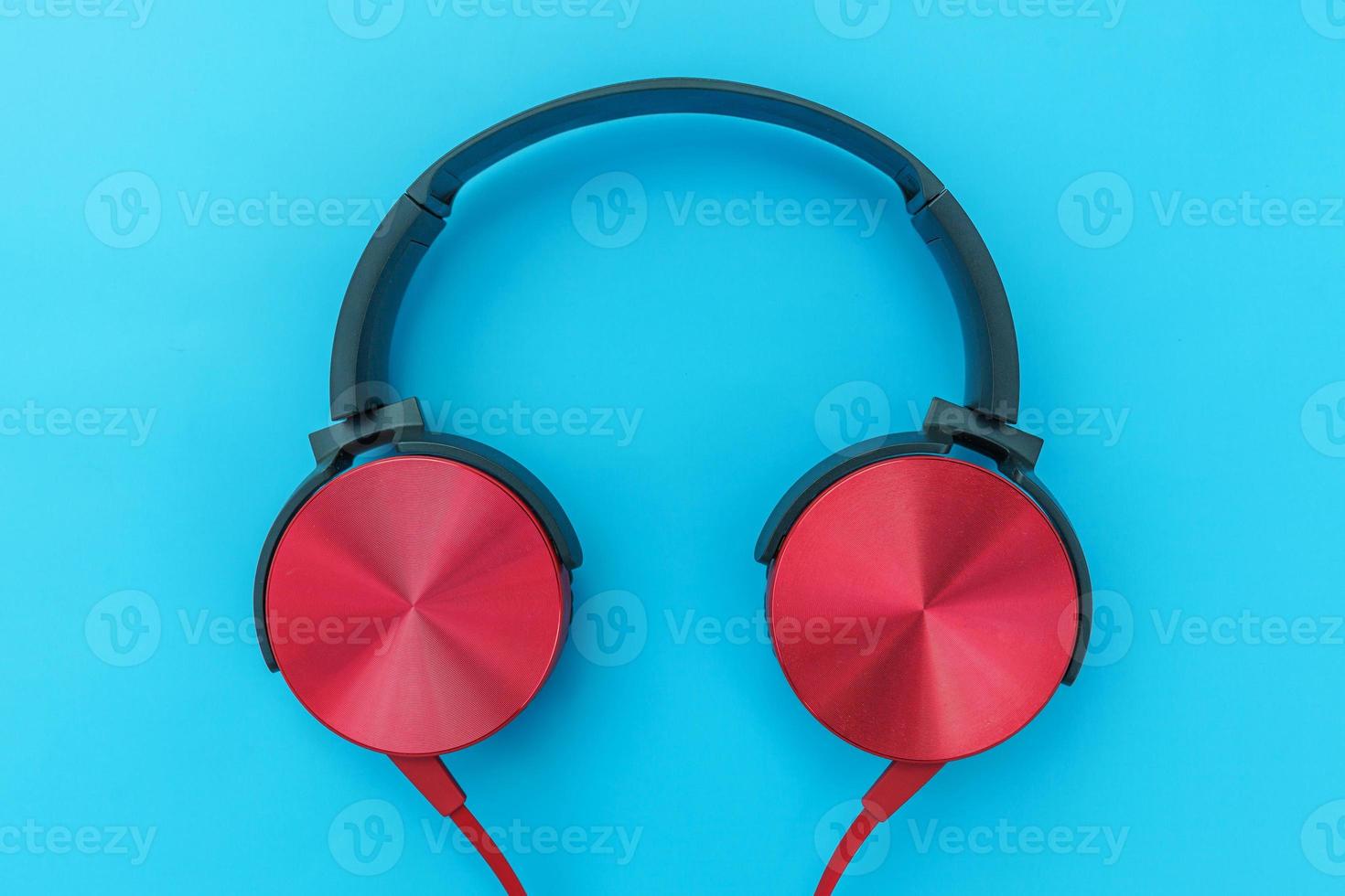 auriculares rojos sobre fondo azul turquesa. foto simple minimalista de auriculares con espacio de copia. auriculares dj rojos con cable aislado en un fondo de colores pastel, vista superior plana. concepto de música