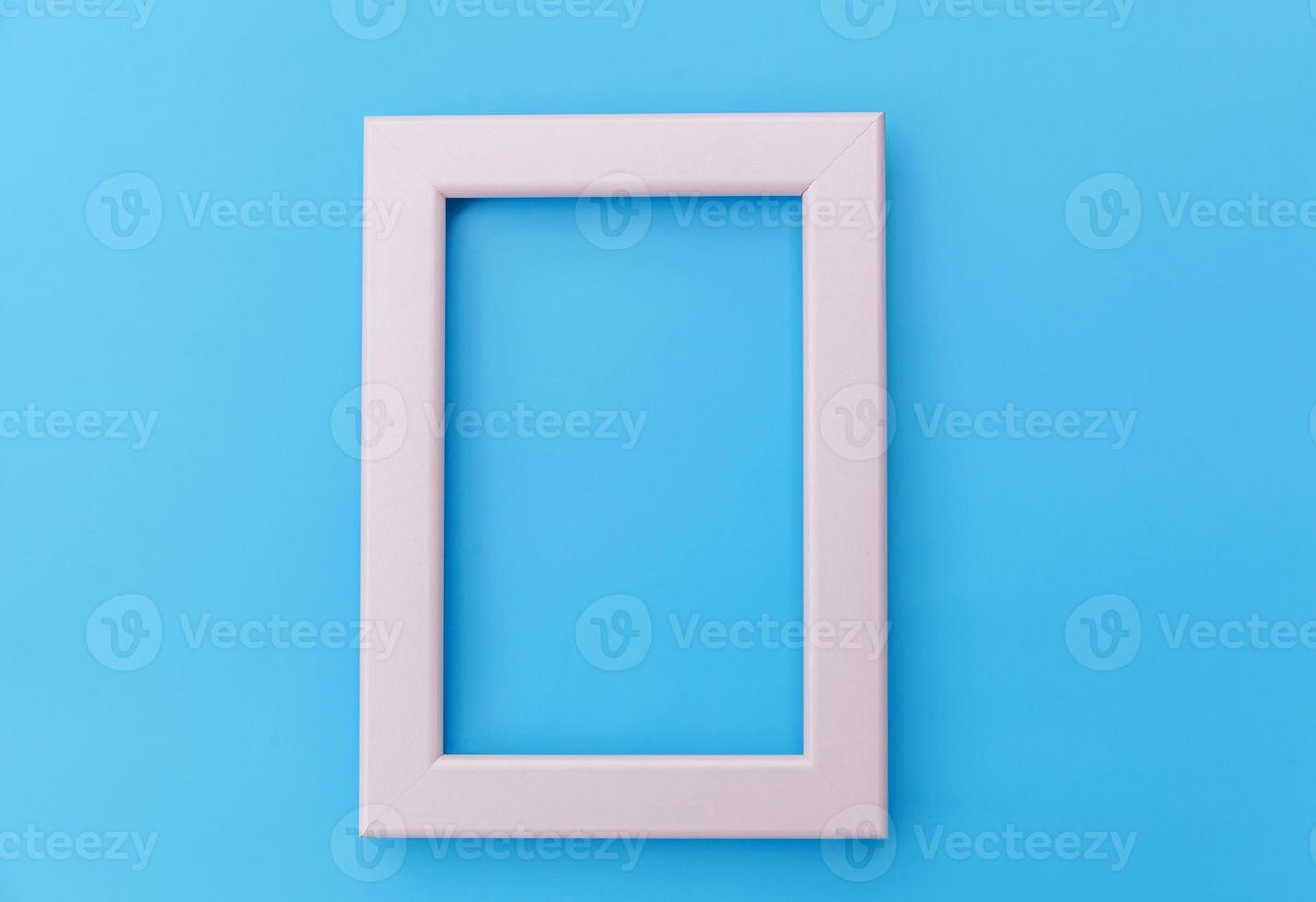Simply design with empty pink frame isolated on blue pastel colorful background. Top view, flat lay, copy space, mock up. Minimal concept. photo