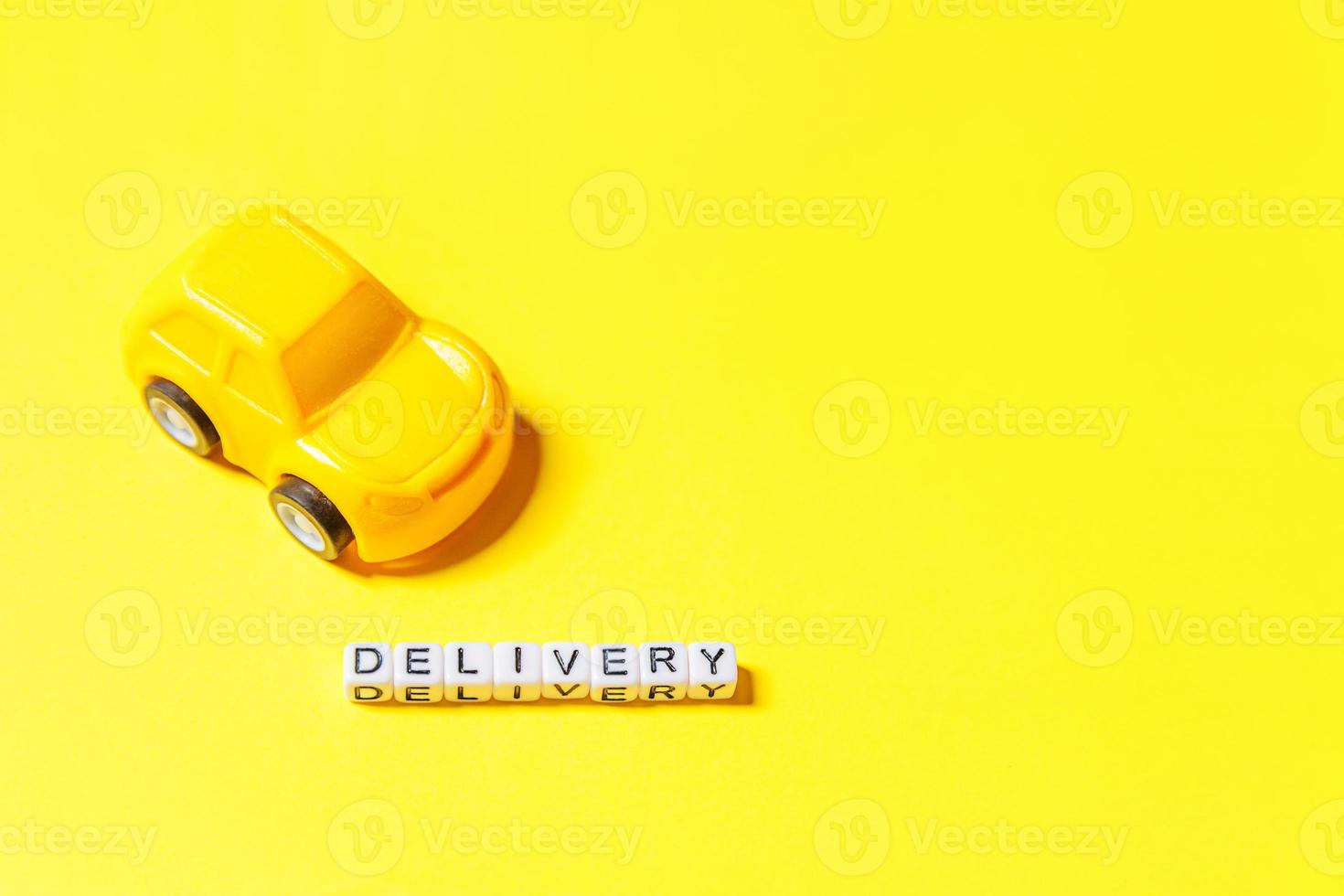 simplemente diseñe un coche de juguete amarillo y una palabra de entrega de inscripción aislada en un fondo colorido amarillo. compras por internet compra en línea paquetes de comercio electrónico servicio de entrega concepto espacio de copia foto