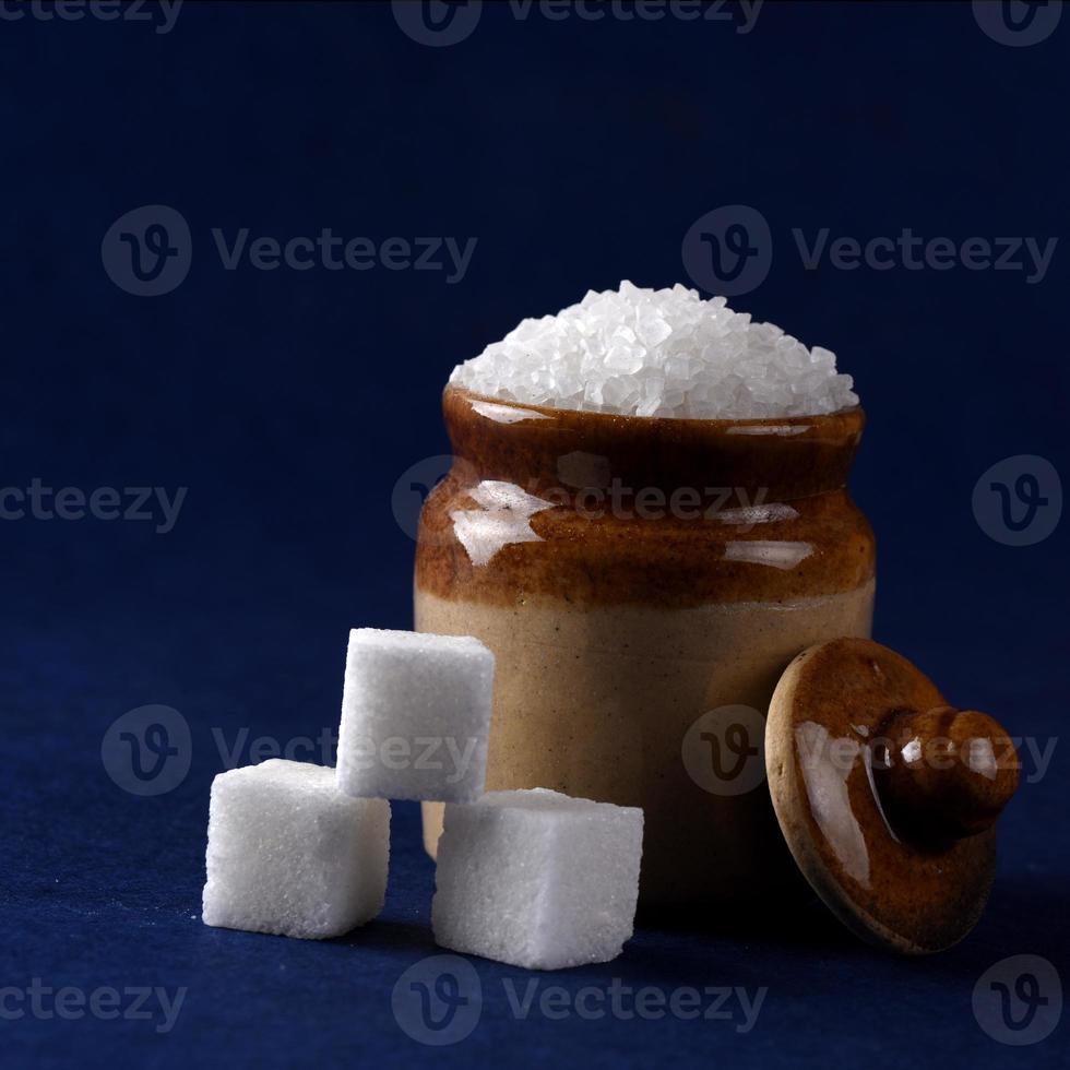 Sugar. white granulated sugar and refined sugar on a blue background photo