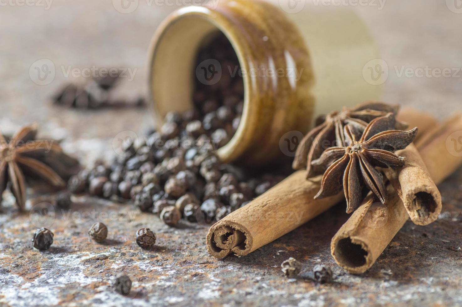 especias y hierbas. ingredientes de la comida y la cocina. palitos de canela, estrellas de anís, granos de pimienta negra sobre fondo de textura foto