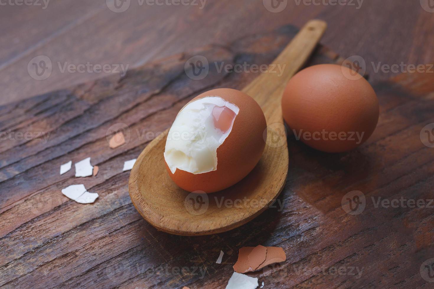 huevos cocidos con cáscaras quitadas en una cuchara de madera foto