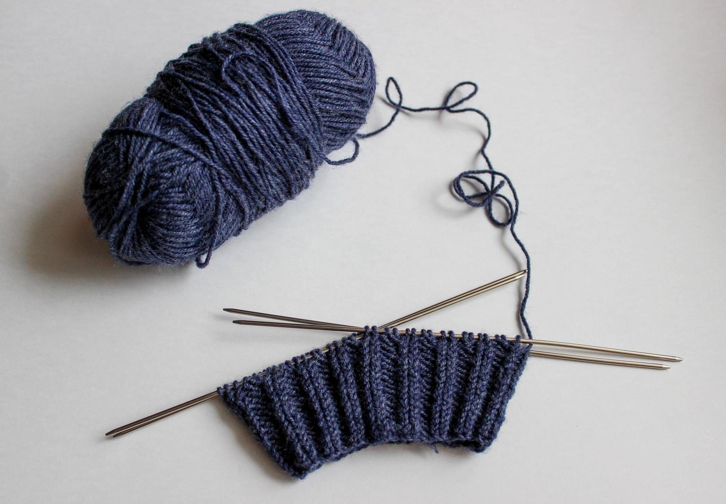 Ball of yarn and knitting needles on white background. Handmade process photo