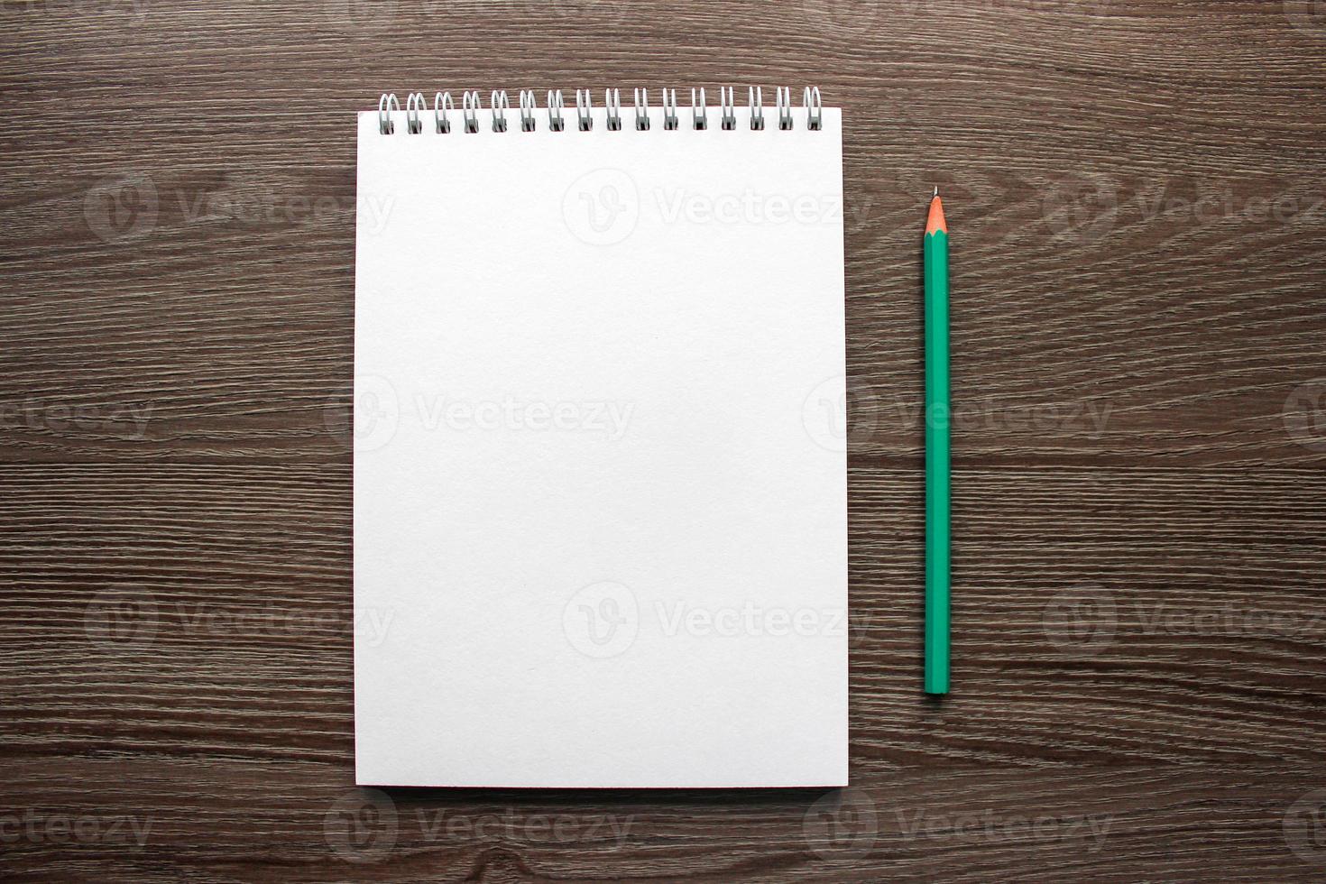 blank sheet of notepad on the desk, next to a pencil photo