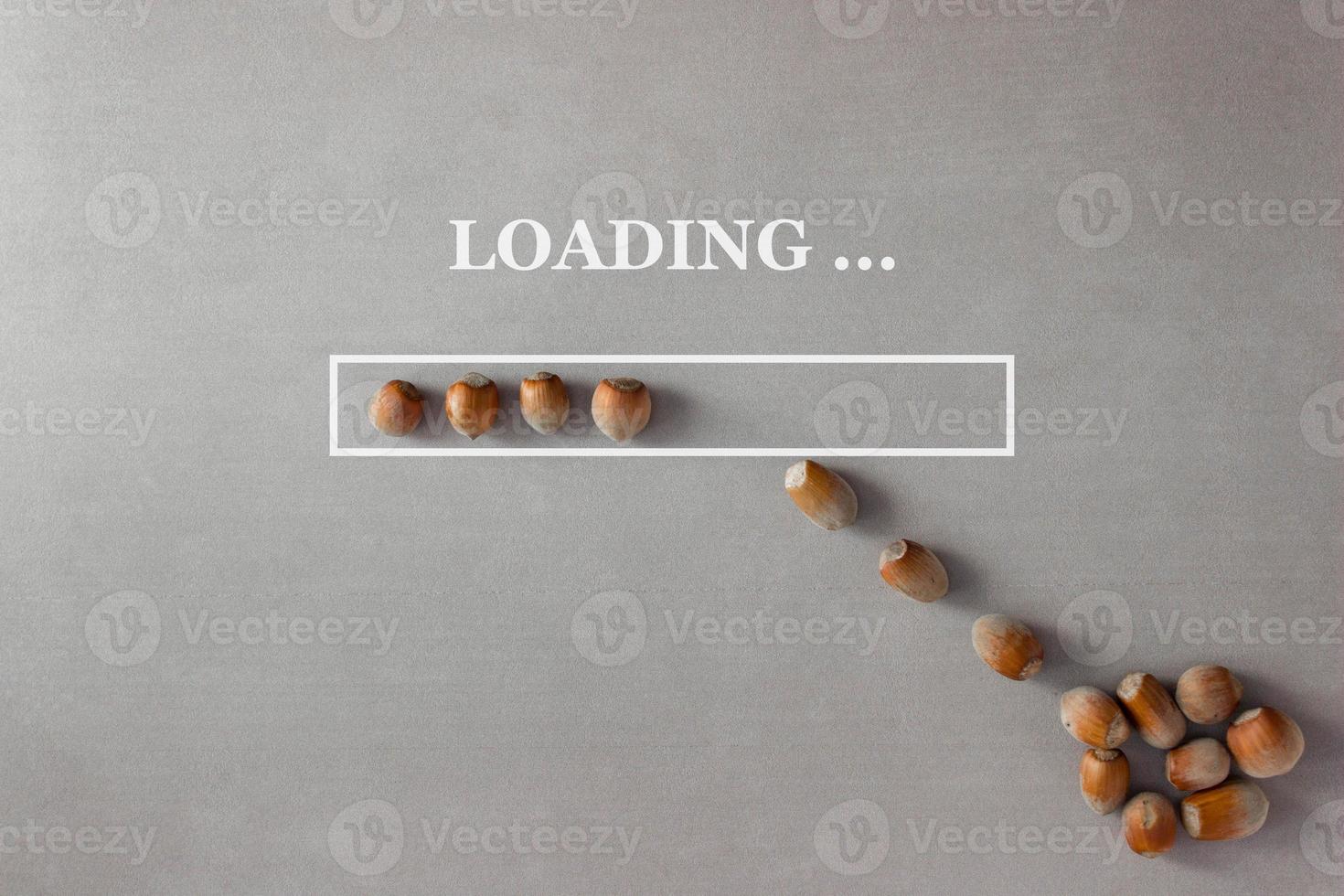 Loading background with hazelnuts in progress bar on gray background which is filled with nuts from a heap lying nearby photo