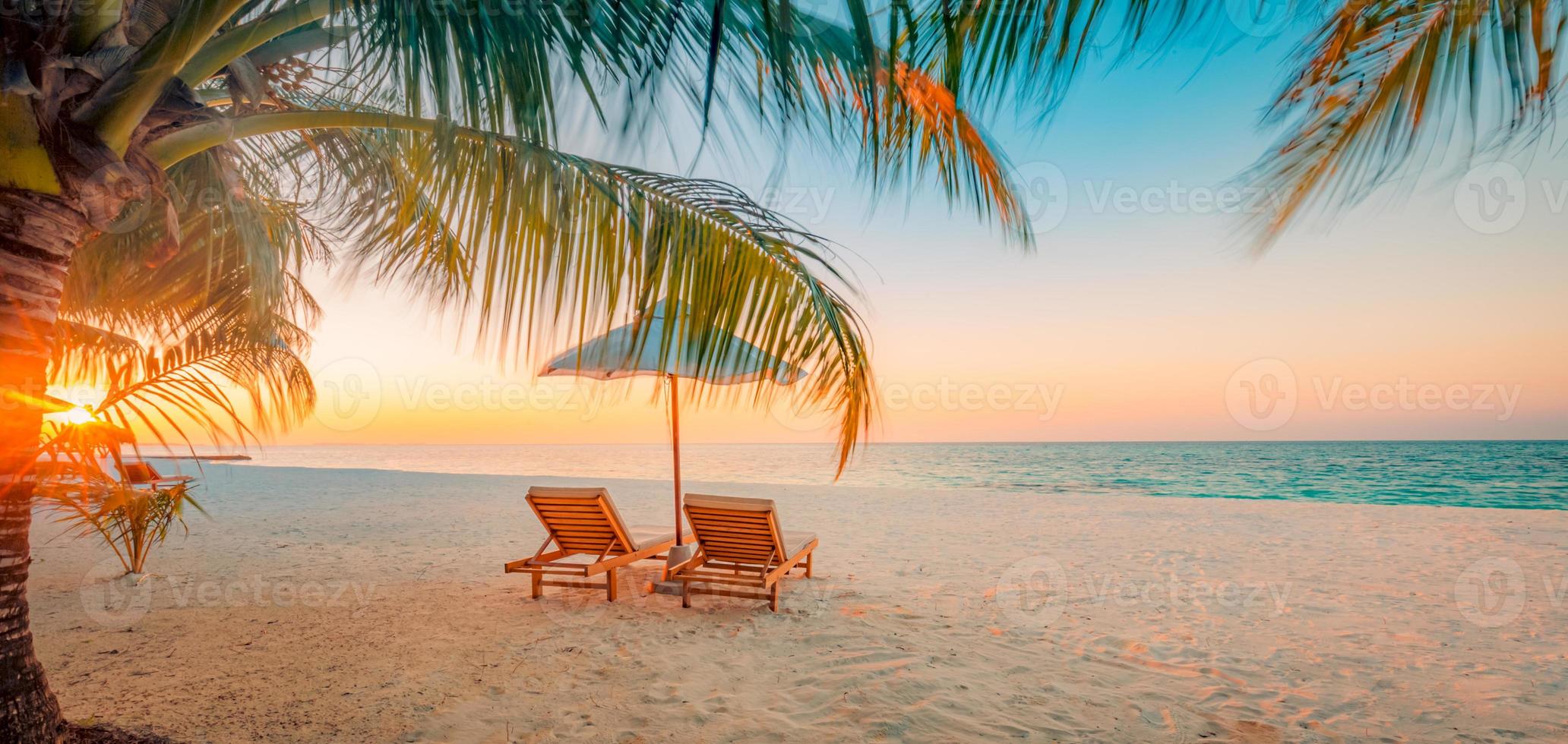 rayos panorámicos de puesta de sol de playa tropical, dos tumbonas, tumbonas, sombrilla bajo palmera. arena blanca, horizonte de la costa del mar, cielo crepuscular colorido, pancarta tranquila y relajante. hotel inspirador en la playa foto