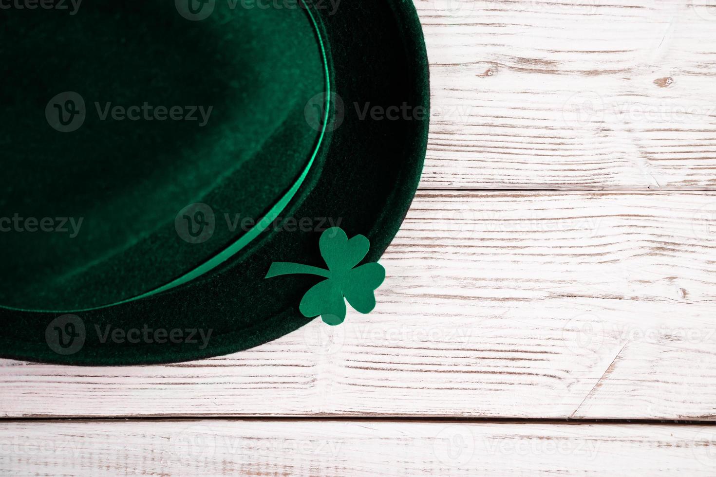 Leprechaun hat and shamrock clover leaves on white background. Happy St. Patrick's Day. photo