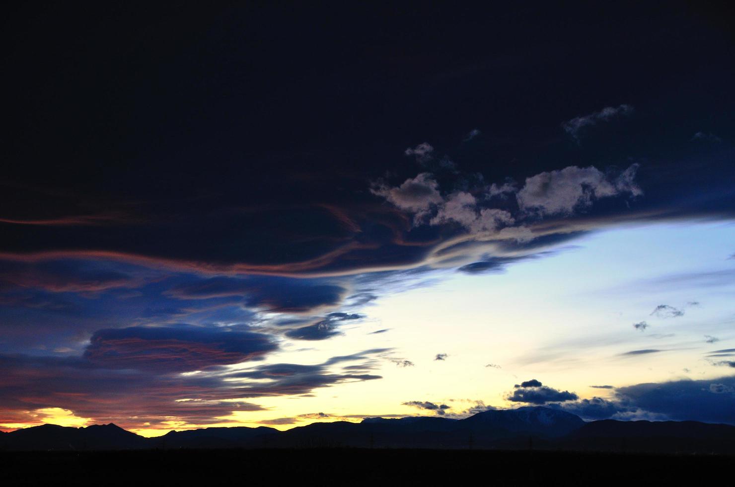 sunset with mountains and black clouds photo