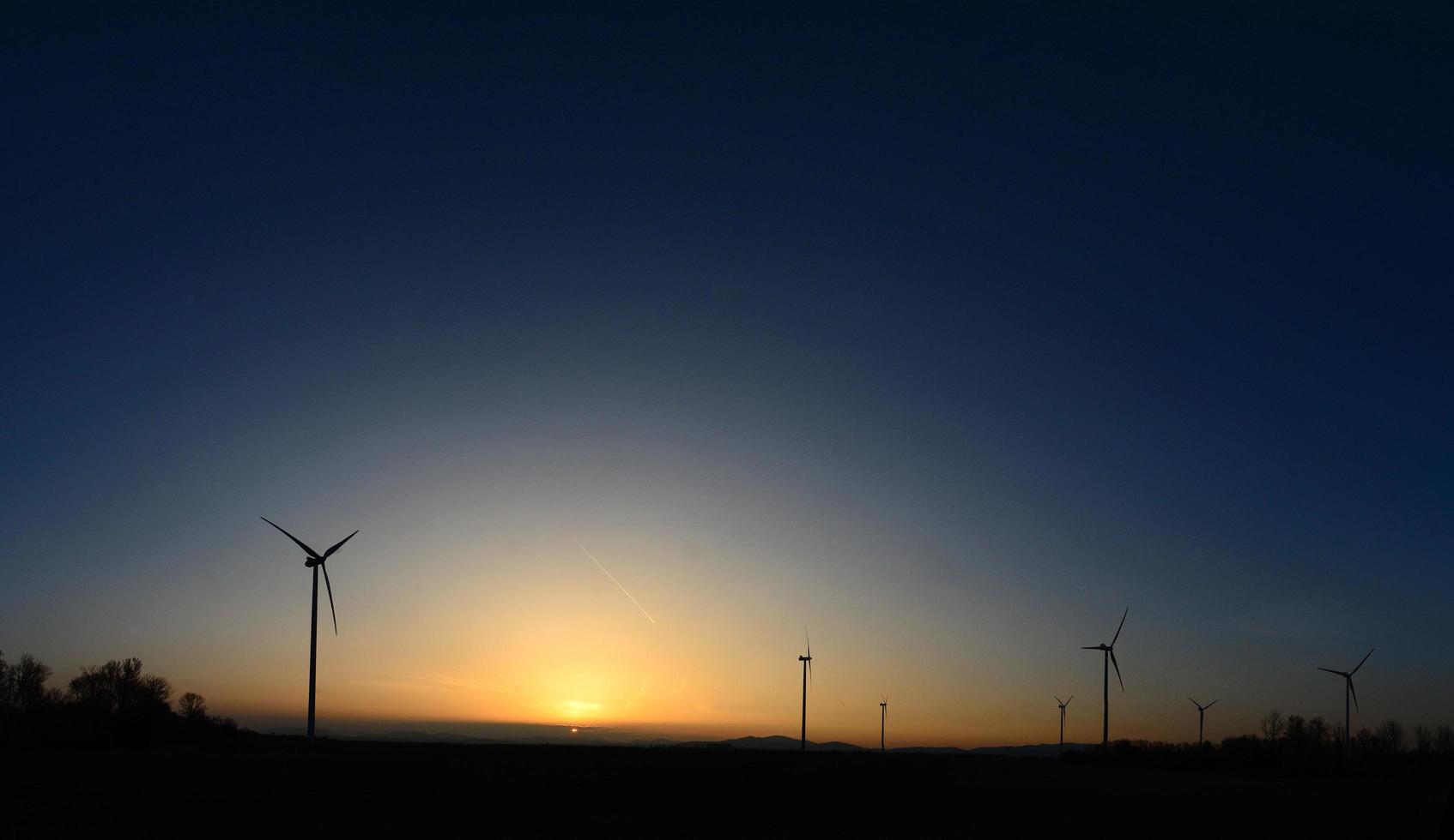 turbinas de viento en el panorama de la puesta del sol foto