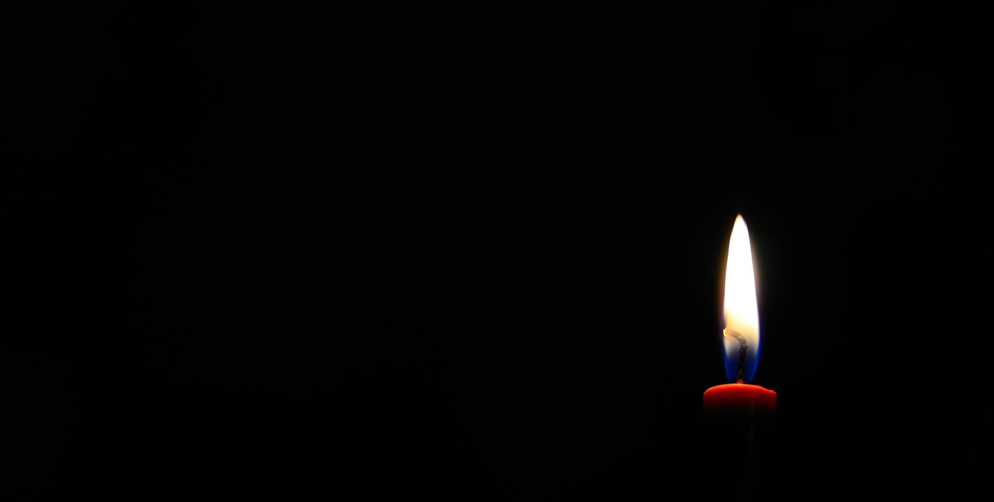 red burning candle and black panorama photo