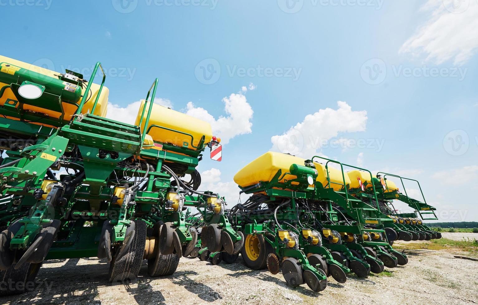 Close up of seeder attached to tractor in field. Agricultural machinery for spring works sowing photo