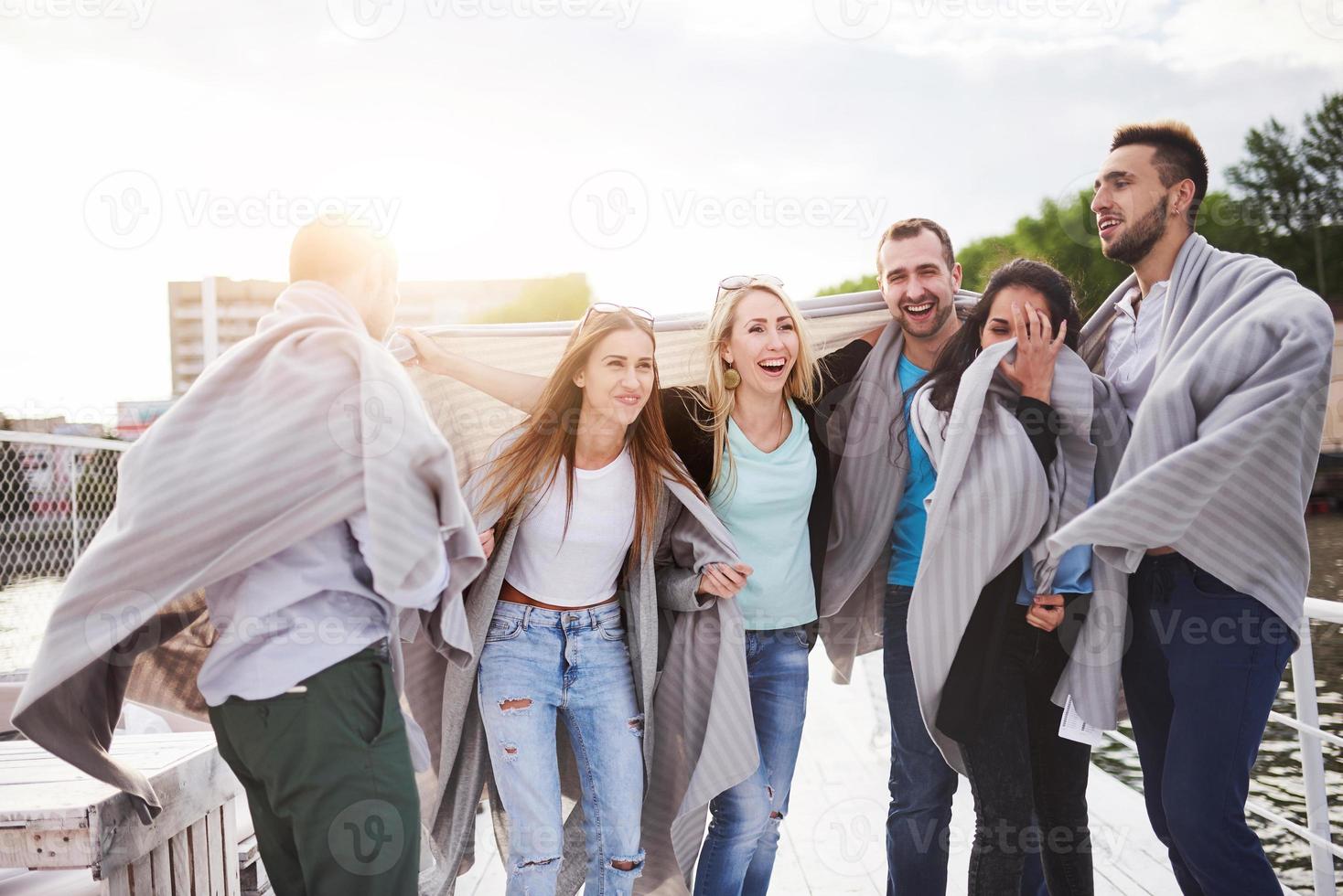 Group of smiling young and successful people on vacation on the dock photo