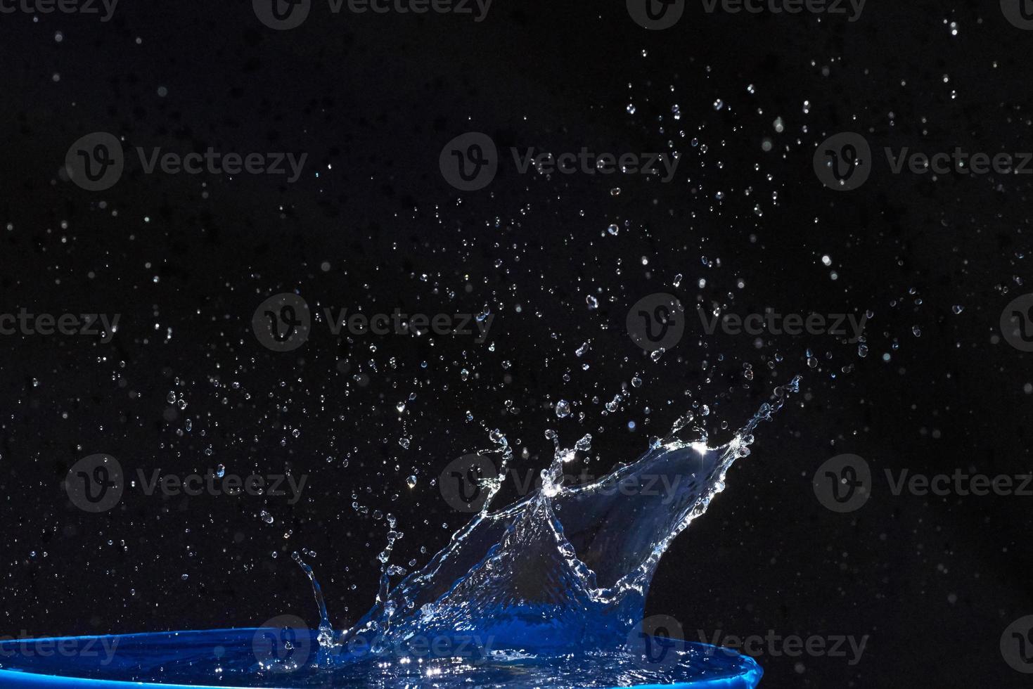 Splash of water crown on blue surface. photo