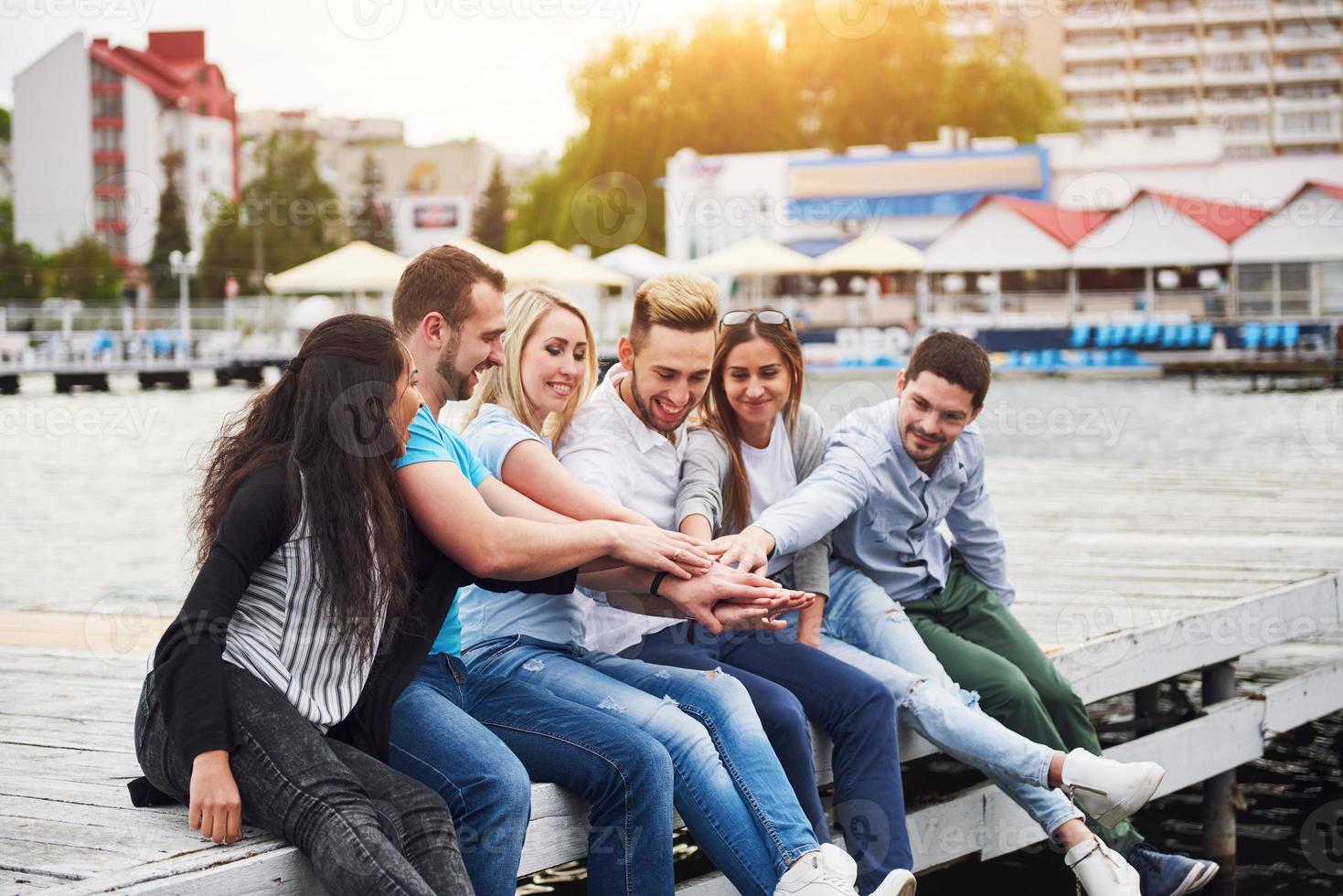Group of happy young friends on the pier, pleasure in playing creates emotional life photo