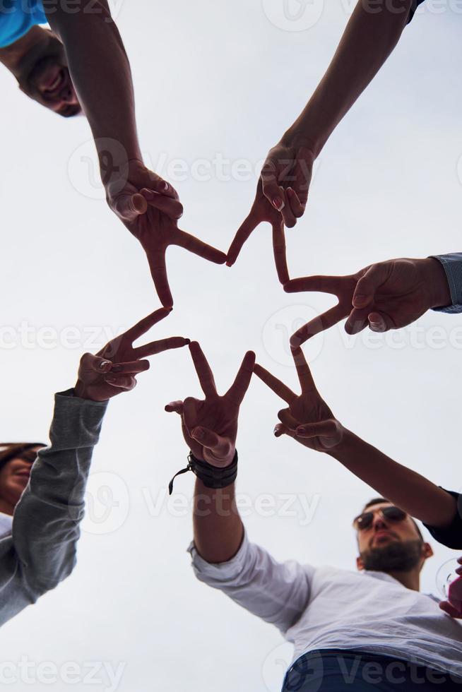 People forming star shape with their fingers photo