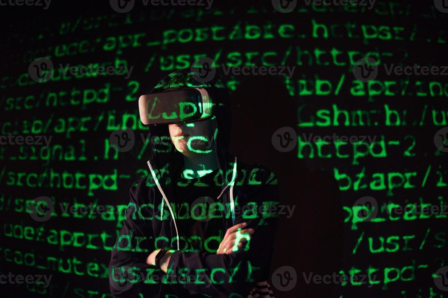 Double exposure of a caucasian man and Virtual reality headset is presumably a gamer or a hacker cracking the code into a secure network or server, with lines of code photo