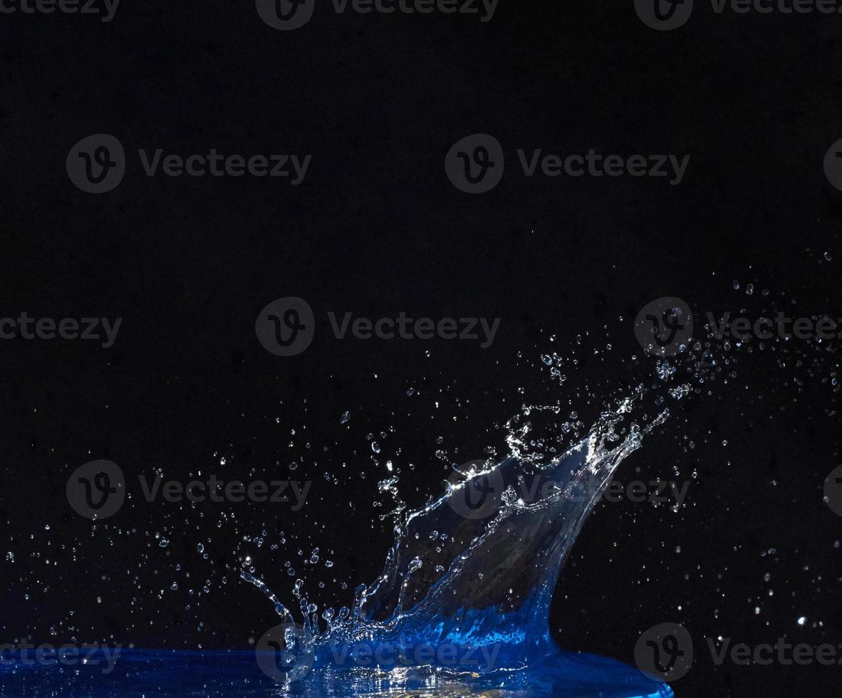 Splash of water crown on blue surface. photo