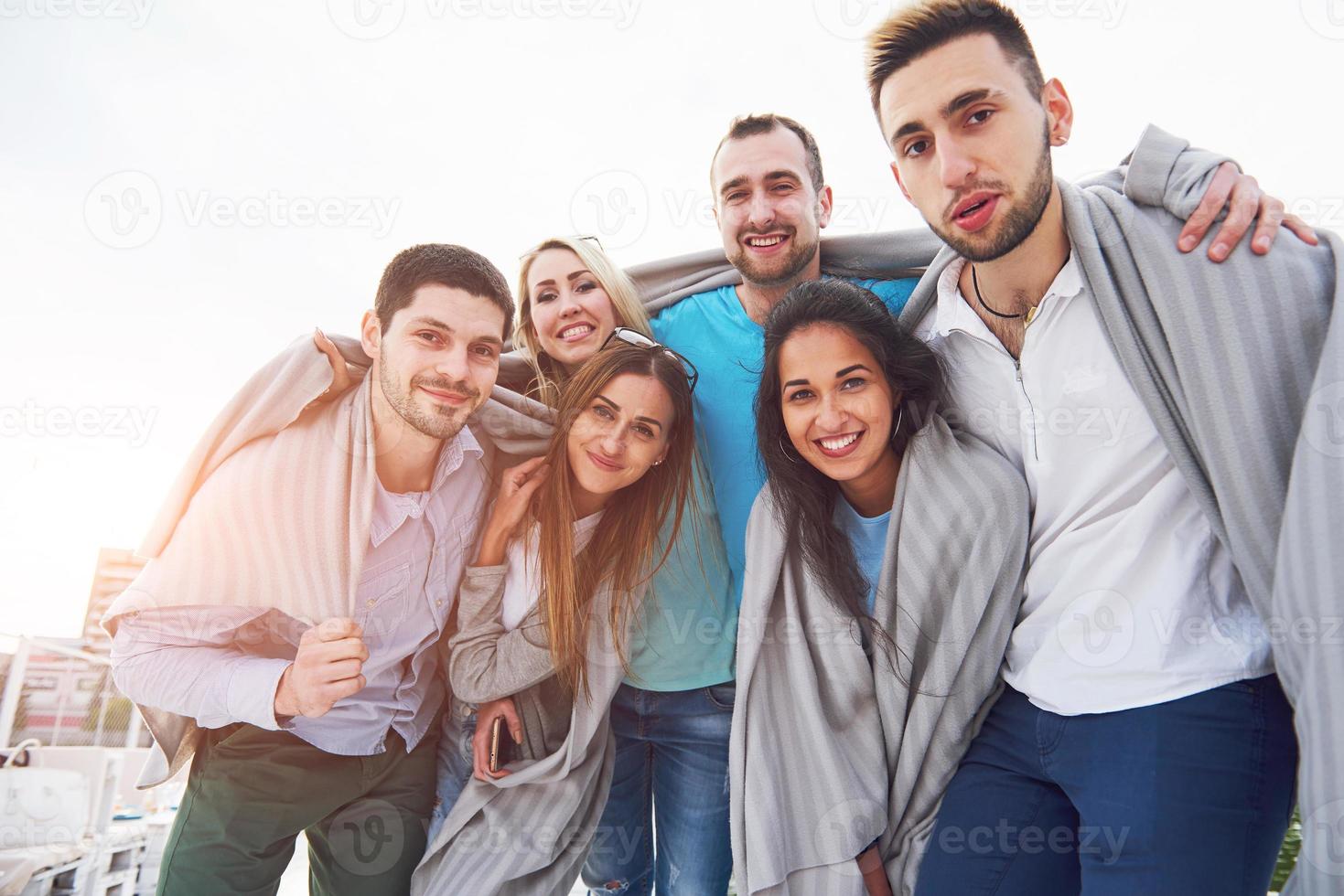 Portrait of a young and happy people at rest on the pier. Friends enjoying a game on the lake. Positive emotions. photo