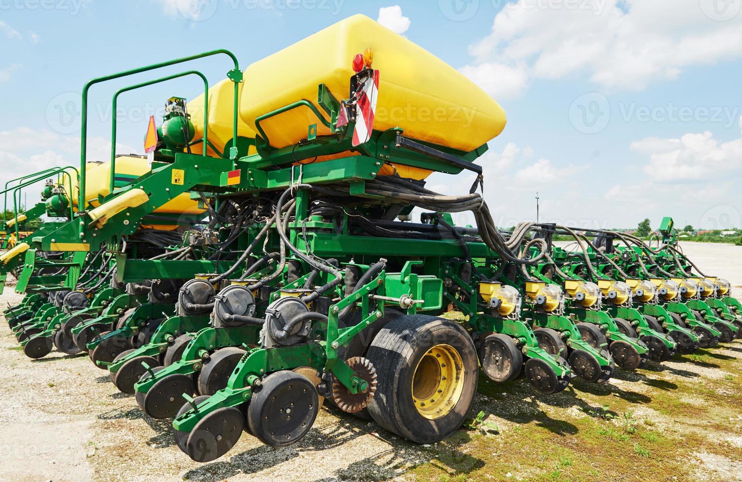 Close up of seeder attached to tractor in field. Agricultural machinery for spring works sowing photo