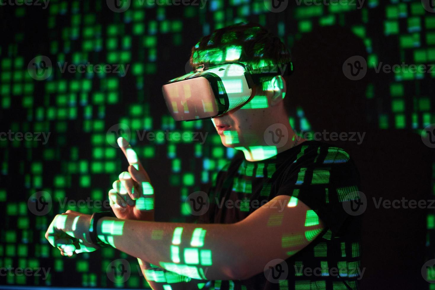 Double exposure of a caucasian man and Virtual reality headset is presumably a gamer or a hacker cracking the code into a secure network or server, with lines of code photo