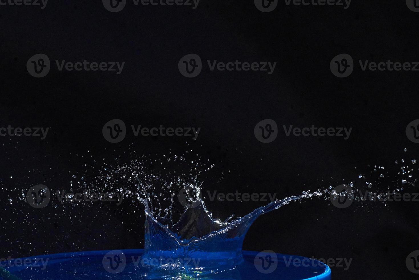 Splash of water crown on blue surface. photo