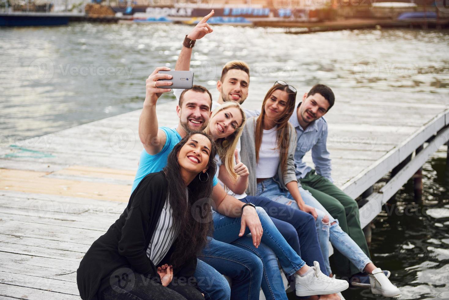 Group of beautiful young people who do Selfies lying on the pier, the best friends of girls and boys with pleasure concept creates emotional life of people. photo