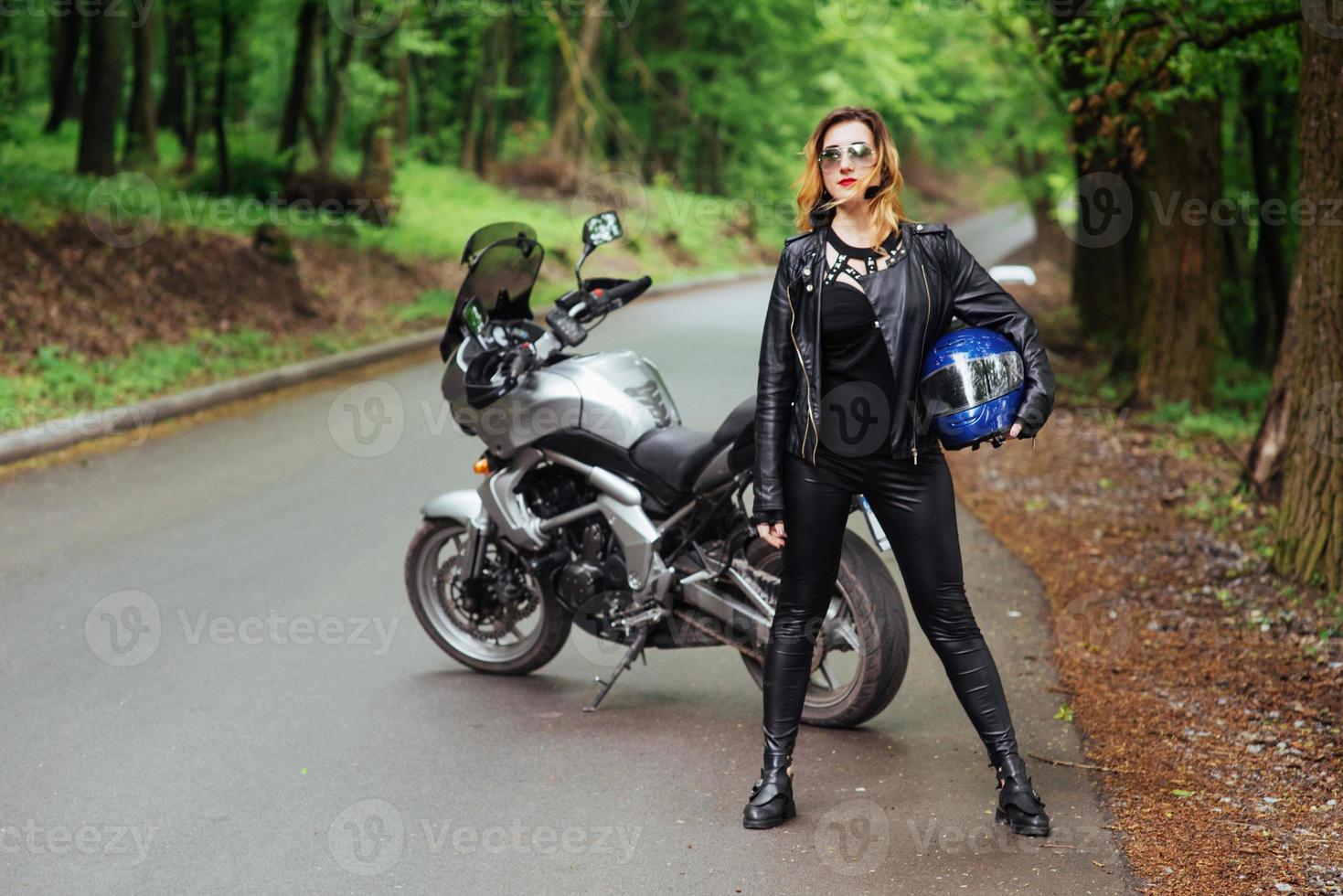 An attractive sexy girl on a sports motorbike posing outside photo