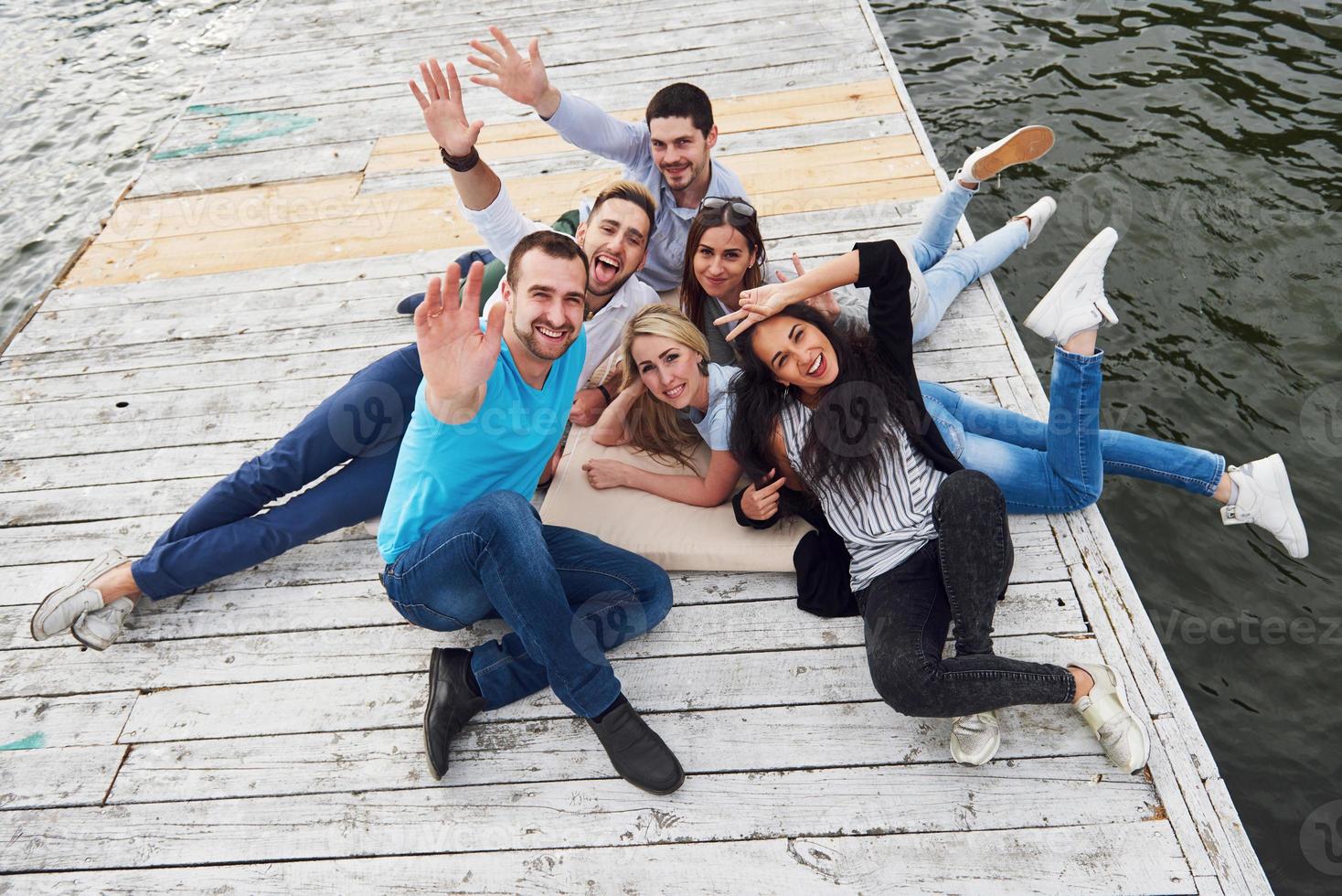 Group of happy young friends on the pier, pleasure in playing creates emotional life photo