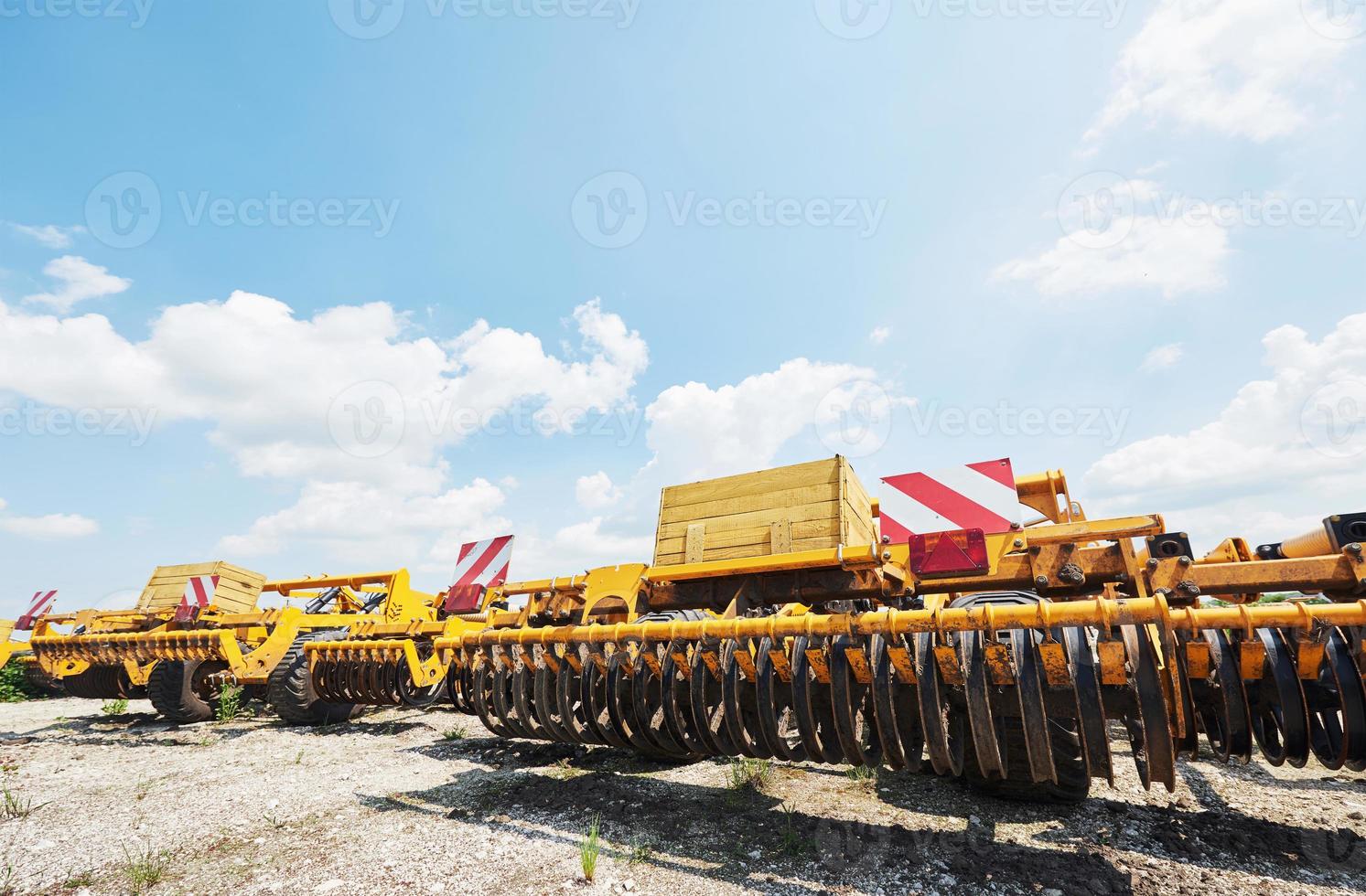 Close up of seeder attached to tractor in field. Agricultural machinery for spring works sowing photo