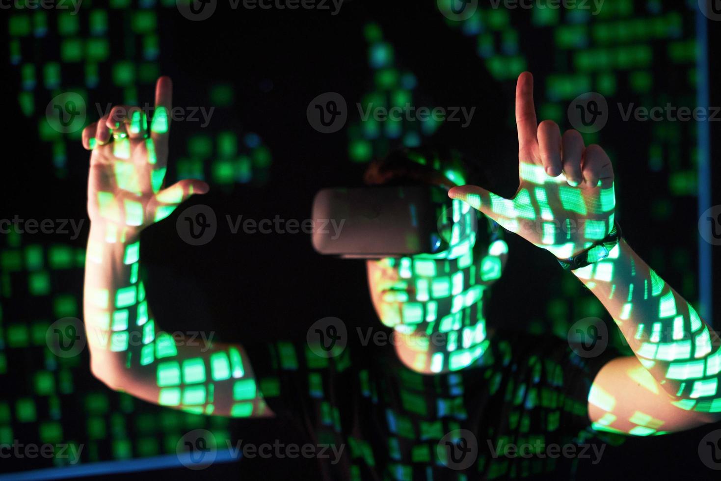 Double exposure of a caucasian man and Virtual reality headset is presumably a gamer or a hacker cracking the code into a secure network or server, with lines of code photo