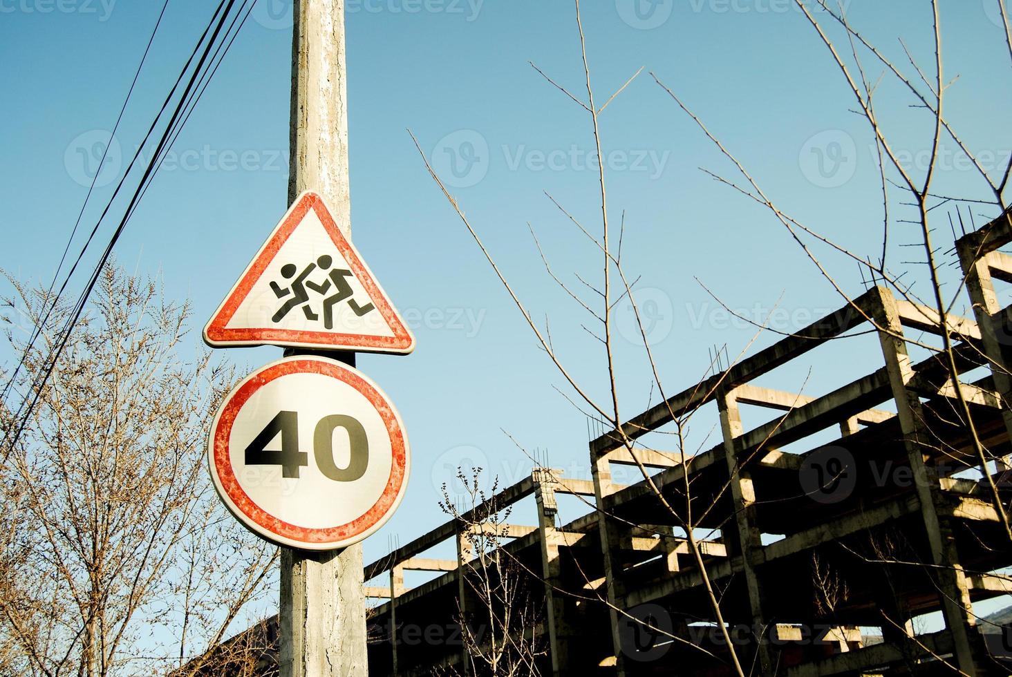 Speed limitation road sign with an unfinished building on background. photo