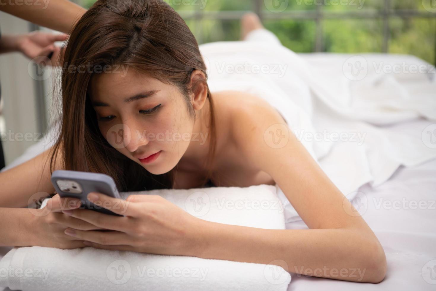 Portrait of young beautiful asian woman enjoys massage in a luxury spa resort photo