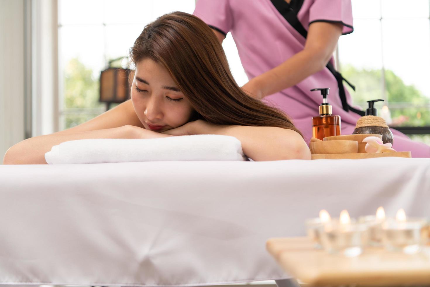 retrato de una joven y bella mujer asiática disfruta de un masaje en un balneario de lujo foto