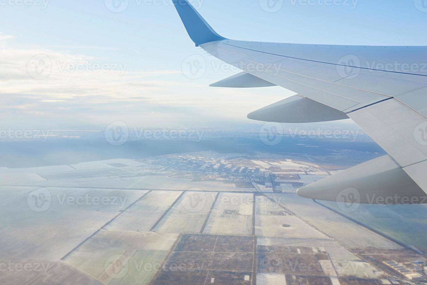 View to the wing of airplane in the sky. Travel and transportation concept photo