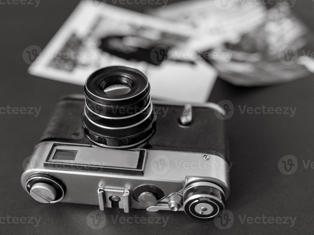 vintage film camera with black and white pictures laying on the table. Vintage, film, old technology concept photo