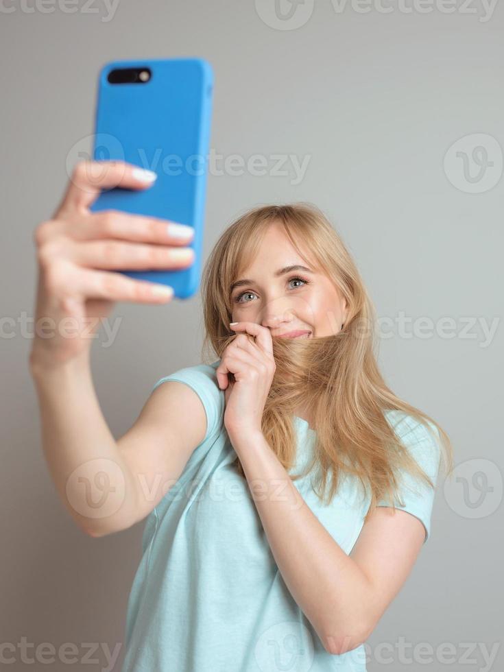 stylish beautiful blonde woman blogger making selfie with her smartphone. Trend, technology, beauty, fashion concept photo