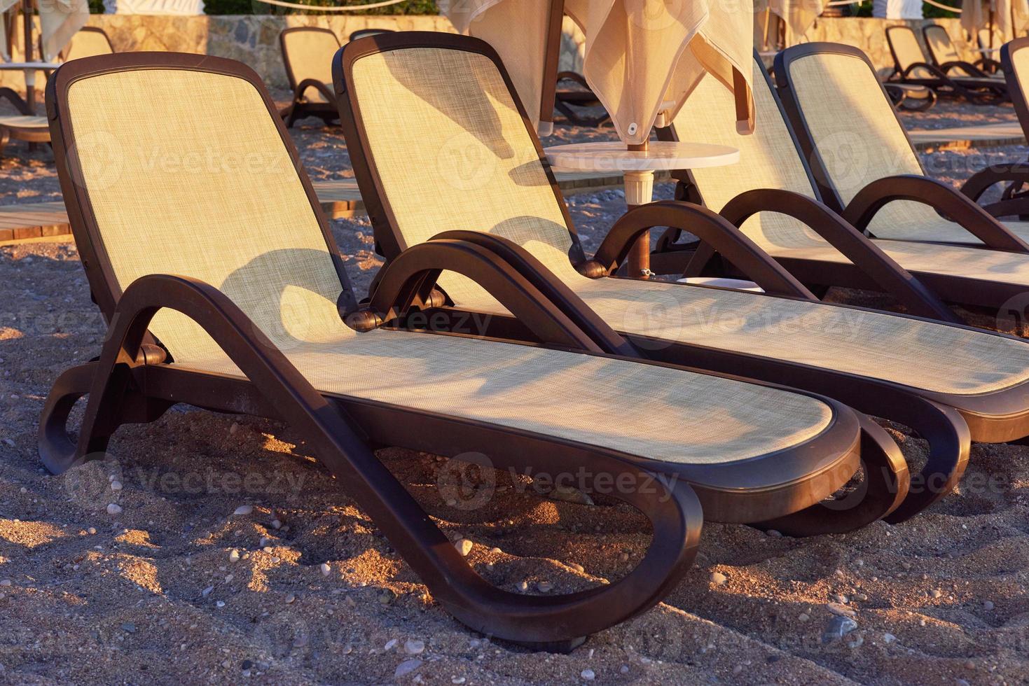 Scenic view of private sandy beach with sun beds and parasokamy the sea and mountains. Resort. photo