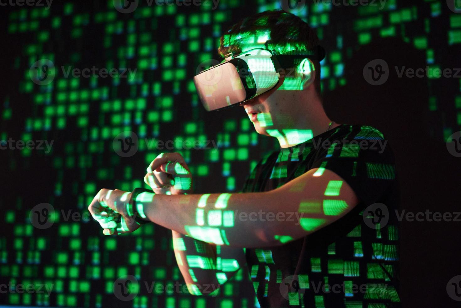 Double exposure of a caucasian man and Virtual reality headset is presumably a gamer or a hacker cracking the code into a secure network or server, with lines of code photo