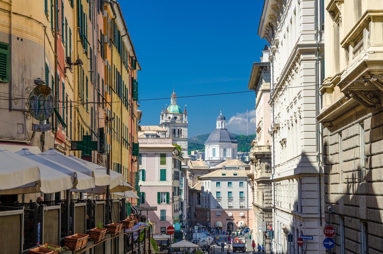 Genoa, Italy, September 11, 2018 Buildings with colorful walls and dome of San Lorenzo Cathedral catholic church background in historical centre of old european city Genova, Liguria photo