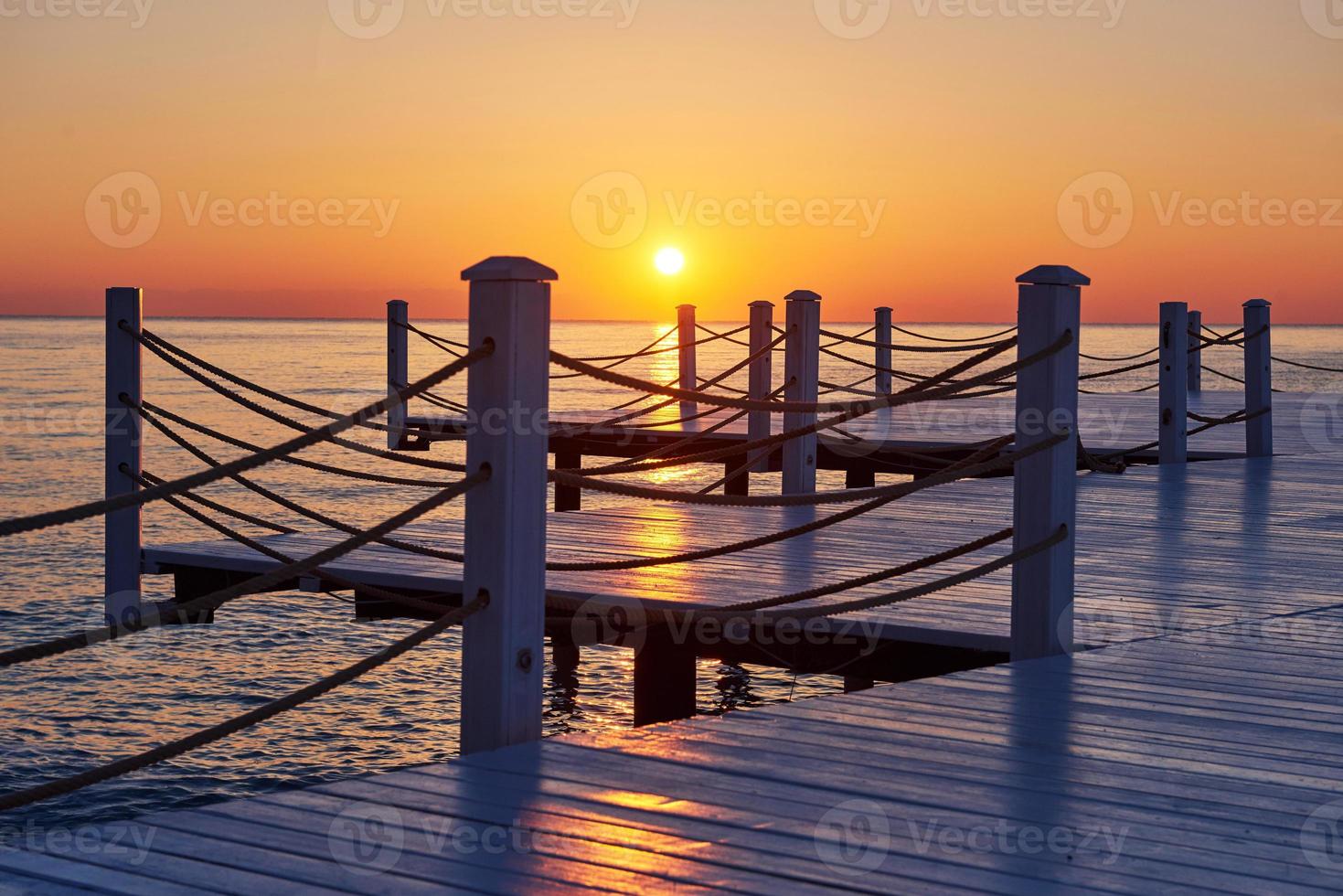 Wooden pier on a fancy orange sunset. photo