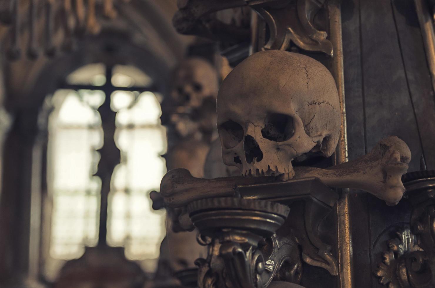 Kutna Hora, Czech Republic, May 14, 2019 Crucifixion of Jesus Christ in window and close-up blurred human scull photo